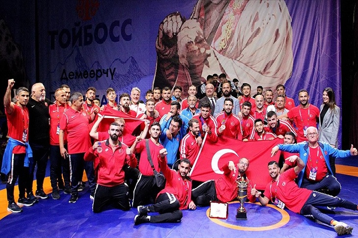 Başarılı sporcuların kazandıkları kupa, madalya ve açtıkları ay yıldızlı bayrakla çekilen bir toplu hatıra resmi objektife yansıyor.