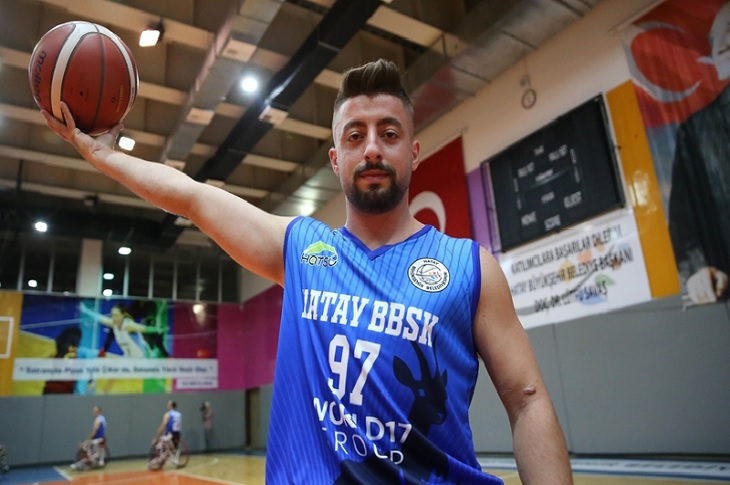 Gazi Yusuf Deli, elindeki basketbol topuyla, kapalı basketbol sahasında objektife yansıyor.