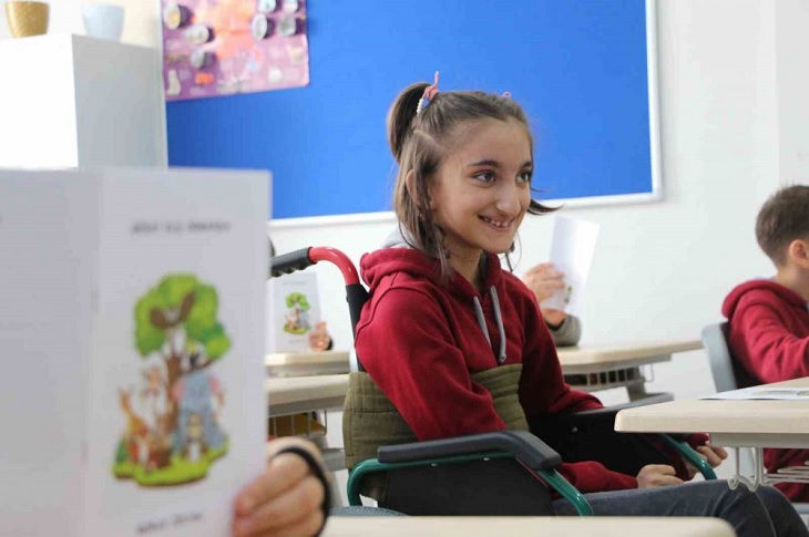 Miray'ın sınıftaki arkadaşlarına dağıttığı kitabının ilgiyle okunmasından duyduğu sevinç objektife yansıyor.