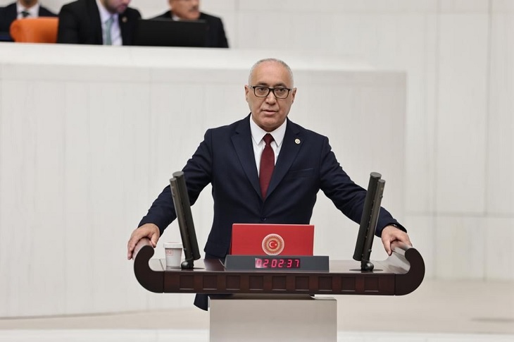 Haberi temsilen, ilgili milletvekilinin meclis kürsüsünde konuşma yaptığı bir resim objektife yansıyor.