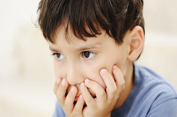 Görselde, bir çocuk var. Ellerini ağzının etrafında birleştirmiş ve öfkeli bir biçimde karşısına doğru bakıyor.