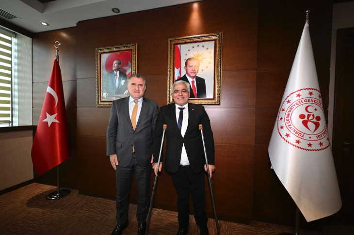 Gençlik ve Spor Bakanı Osman Aşkın Bak ve TBESF Başkanı Alpaslan Erkoç yan yana ayakta poz veriyor.