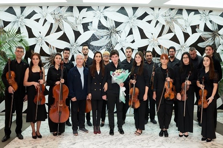 Konseri veren müzisyenlerin toplu hatıra resmi objektife yansıyor.