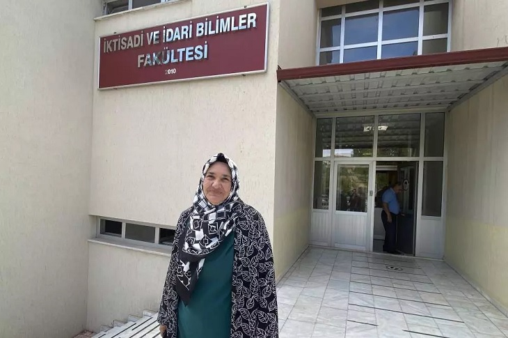 Nurten Yurttaş, kazandığı İdari ve İktisadi Bilimler Fakültesi bölümü ana giriş kapısı önünde objektife yansıyor.