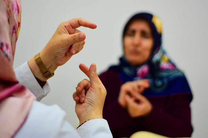 İşaret dili ile Kur'an eğitimi verilen bir bayan objektife yansıyor.