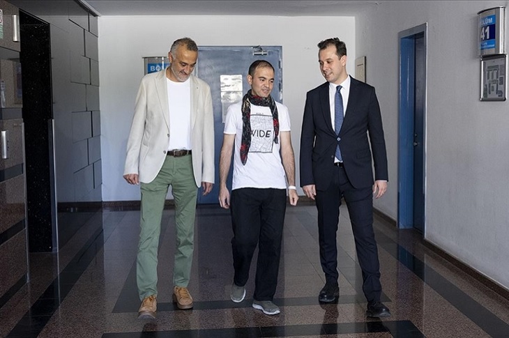 Sağlığına kavuşan Yusuf, iki doktoru ile birlikte, hastane koridorunda objektife yansıyor.