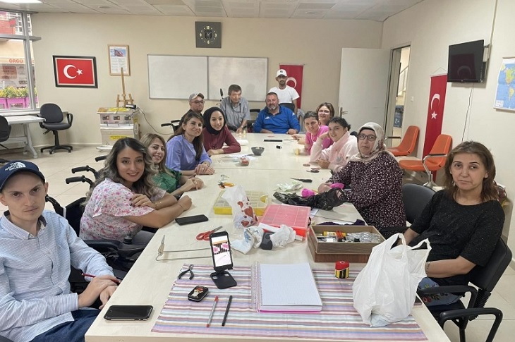 Aynı masada bir araya gelen çok sayıda kursiyer objektife yansıyor.