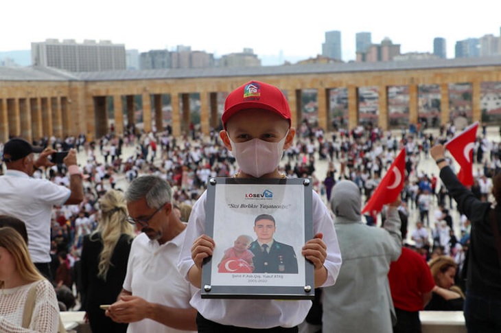 Anıtkabir'e gelen lösemili çocuk, elindeki şehit astsubayın çerçeveli resmi ile objektife yansıyor.