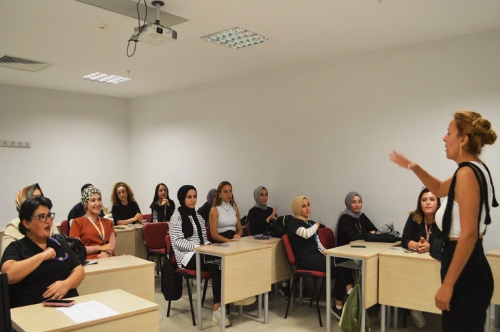 Sınıfta, dersi takip eden çok sayıda katılımcı objektife yansıyor.