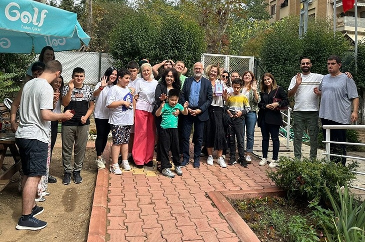 Otizmli öğrencilerin bir toplu hatıra resmi objektife yansıyor.