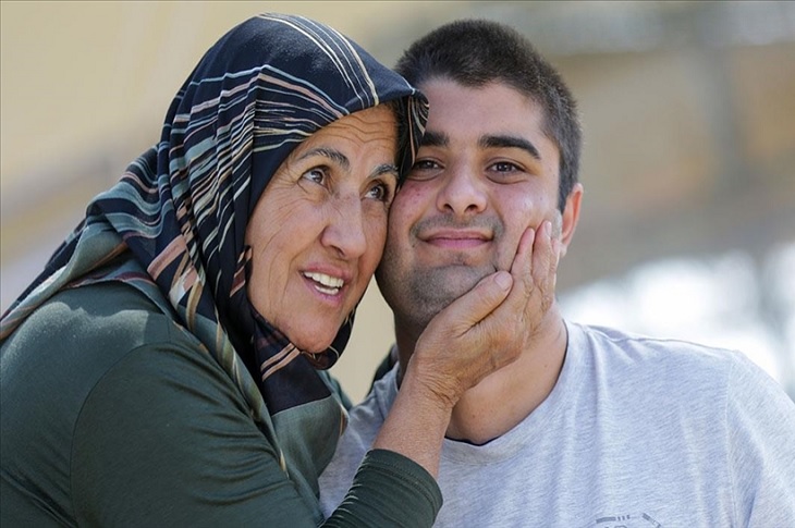 Otizmli Yiğit, kendisine sarılan babaannesi ile birlikte objektife yansıyor.