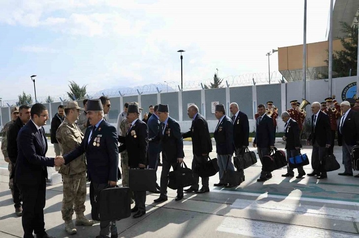 Gazileri uğurlayan yetkililerin gazilerle bir bir el sıkıştığı ana dair bir görüntü objektife yansıyor.