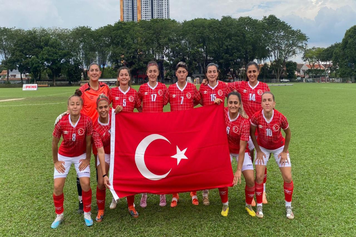İşitme Engelli Futbol Kadın Milli Takımı, Türk bayrağı açarak poz veriyor.