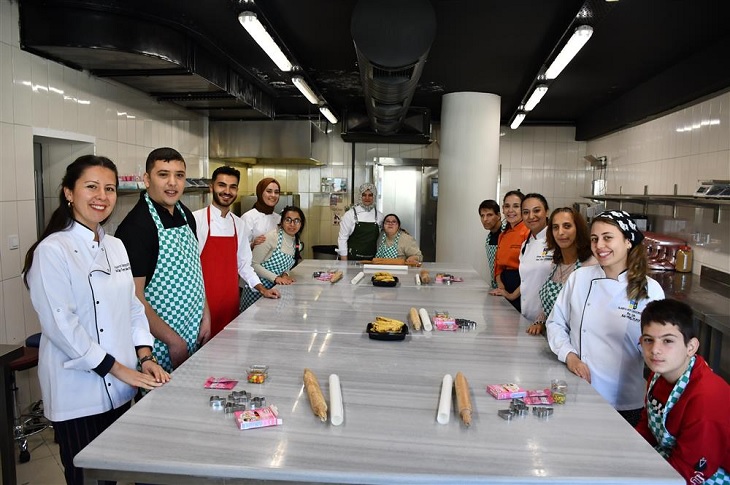 Mutfaktaki dev masa etrafında çekilen bir toplu hatıra resmi objektife yansıyor.