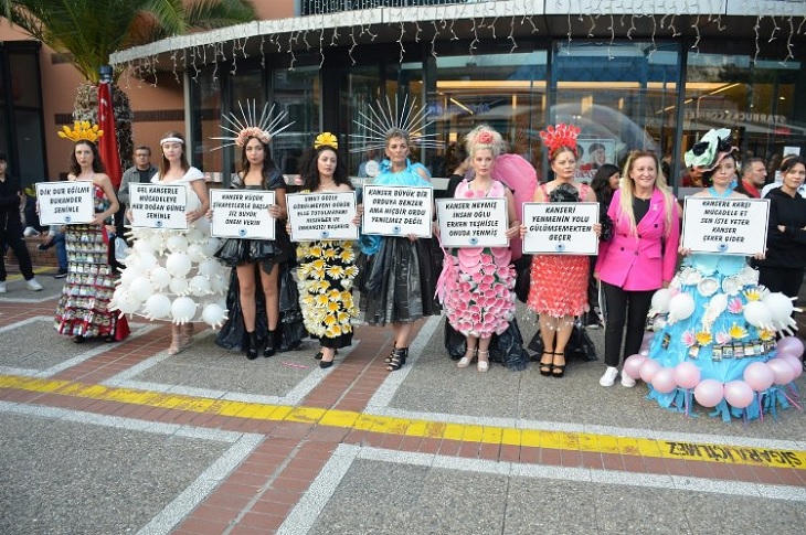 Defileye çıkan mankenlerin ellerindeki yazılı pankartlarla çekilen bir toplu hatıra resmi objektife yansıyor.