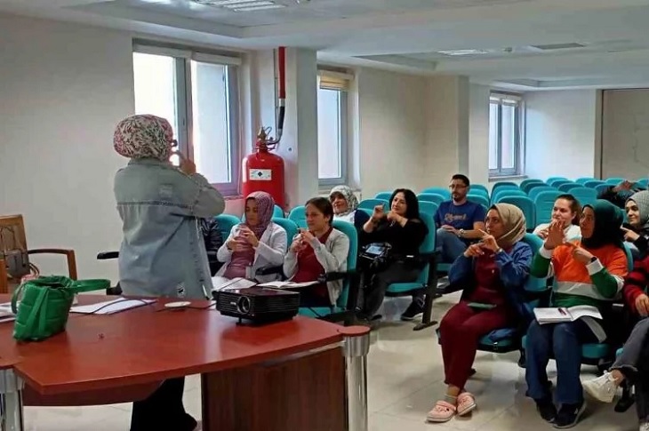 Çok sayıda katılımcı ile işaret dili pratiğinin yapıldığı ana dair bir resim objektife yansıyor.