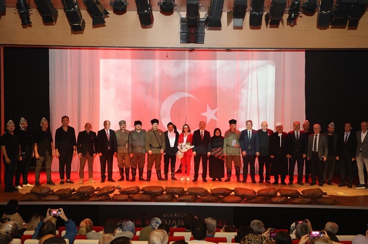 Sahnede çekilen bir toplu hatıra resmi objektife yansıyor.