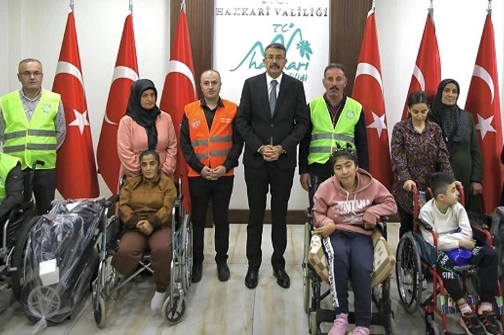 Valilik makamında, araçlarını teslim alan engelli bireylerle çekilen bir toplu hatıra resmi objektife yansıyor.