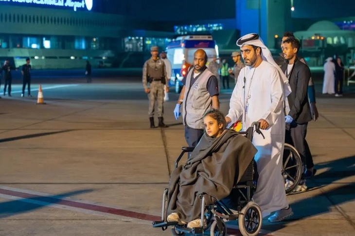 Havalimanında tekerlekli sandalye ile taşınan engelli çocuk objektife yansıyor.