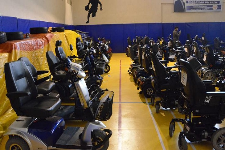 Kapalı spor salonunda, sıralı halde olan akülü araçlar objektife yansıyor.