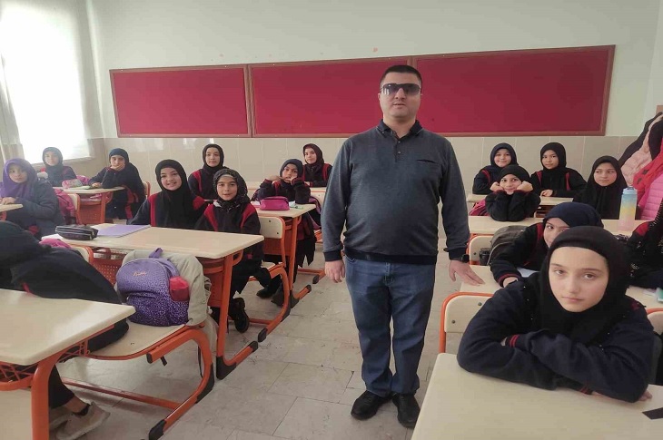 Serkan öğretmen, sınıftaki öğrencileriyle birlikte objektife yansıyor.