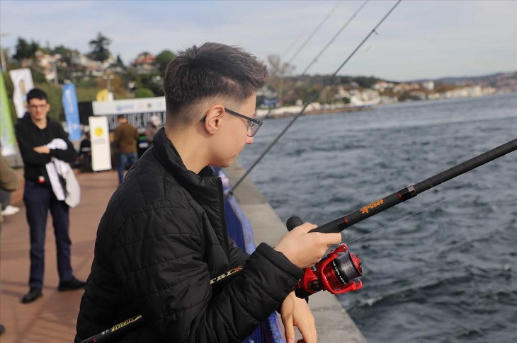 Oltasıyla sahil kenarında balık avlayan bir engelli birey objektife yansıyor.