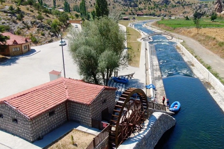 Yapay su kanalı kenarındaki değirmenin havadan bir görüntüsü objektife yansıyor.