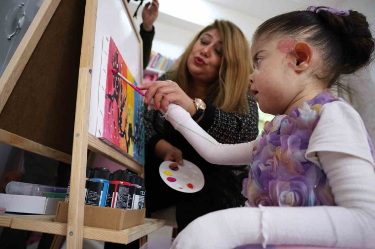 Görsel sanatlar öğretmeni Sibel Çelik, kelebek hastası Fatma Aydın ile resim çiziyor.