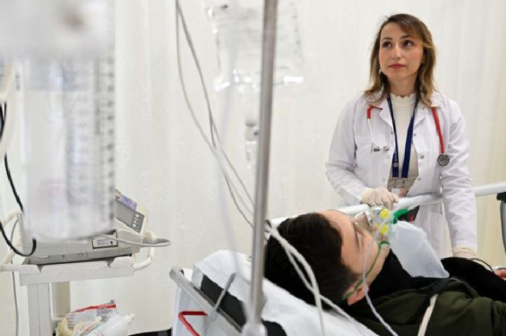 Doktor Nurgül Erfidan hastanede sedyede uzanan hastasını muayene ediyor.