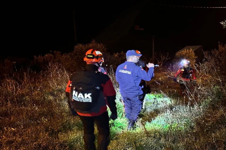 Arama kurtarma personeli iki erkek ellerinde gece feneri tutarak çalışma yapıyor.