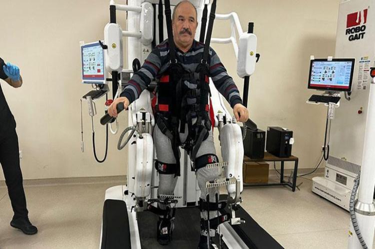 Omurilik felçli Osman Mermerkaya, robotik rehabilitasyon cihazında yürüyor.