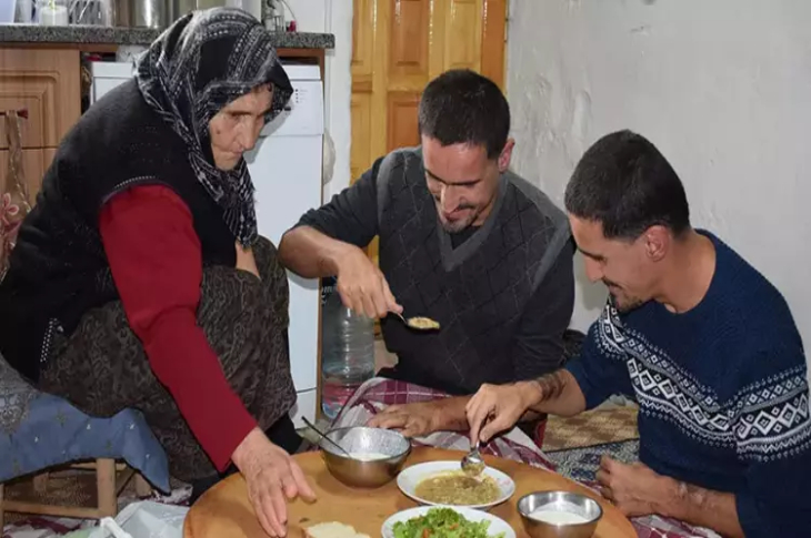 Anne ve engelli çocukları kahvaltı yapıyor.