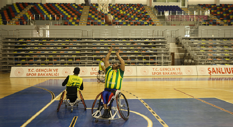 Şanlıurfa BESK tekerlekli sandalye baketbol takımından 2 oyuncu basket atarken görseli