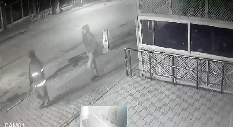 Sokak kamerasında karanlıkta kaldırımda yürüyen iki şahıs görseli