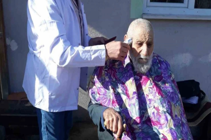 Yaşlı erkeğin saçları kesiliyor.