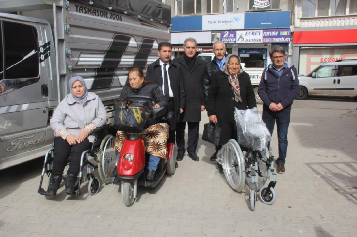 Bağış yapanlar ile engelliler hatıra fotoğrafı çektiriyor.