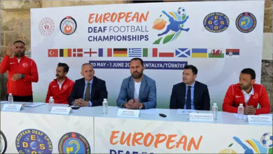 10. İşitme Engelliler Avrupa Futbol Şampiyonası'nın lansman ve basın toplantısında görevli kişiler oturarak konuşuyor ve işitme dili çevirmeni engelli bireyler için çeviri yapıyor.