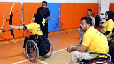 Tekerlekli sandalye kullanıcısı bedensel engelli bireyler okçuluk antrenmanı yapıyor.