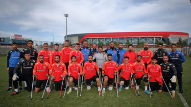 Ampute Milli Futbol Takımı oyuncuları ve antrenörleriyle birlikte futbol sahasında fotoğraf çektirmiş.