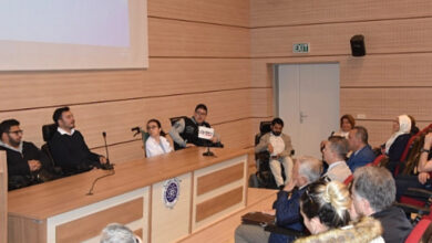 Bedensel engelli öğretmen Aykut Garip ve tekerlekli sandalye kullanıcısı engelli bireyler, akademik personel ve öğrenciler e konuşma yapıyor.