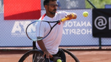 Tekerlekli sandalye kullanıcısı Uğur Altınel, tenis raketiyle atışı karşılıyor.