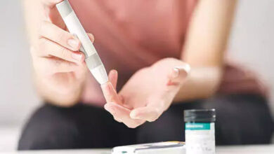 Şeker ölçümü yapan cihaz ile bir kişi parmak ucuna doğru tutarak ölçüm yapıyor.