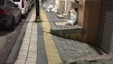 Kaldırım üzerinde bulunan görme engelli yolunda bir binanın girişinden başlayan taş duvar kapatıyor.