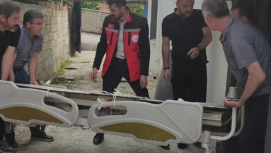 Hasta yatağını beş erkek parça parça evin içine taşıyor.