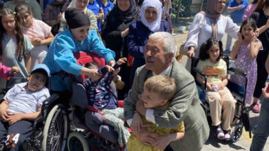 Engelli çocuklar ve aileleri toplu bir şekilde fotoğraf çekiliyor.