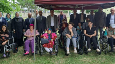 Tekerlekli sandalye ve akülü tekerlekli sandalye kullanan engelli bireyler ve etkinliği düzenleyen görevliler fotoğraf karesinde var.