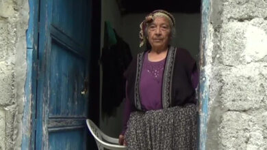 Sıvasız bir evin girişinde Güllü Söyler ayakta duruyor.