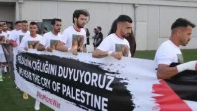 İşitme Engelliler Futbol Milli Takımı, yarı final maçına çıkarken ellerinde uzun yazılı bir pankart var.