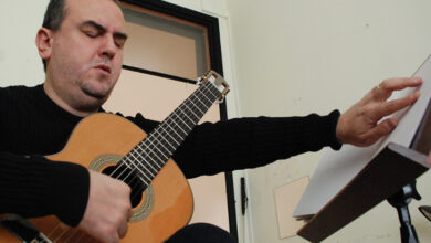 Onur Yılmaz, braile harfleriyle yazılmış notaları okuyarak gitar çalışması yapıyor.