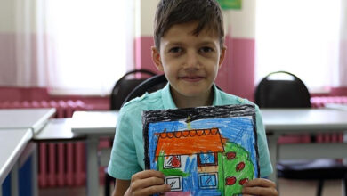 Süleyman Özcan çizdiği resmi elinde tutuyor.